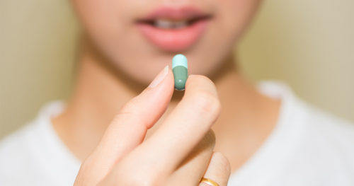 Close-up of woman taking antibiotics