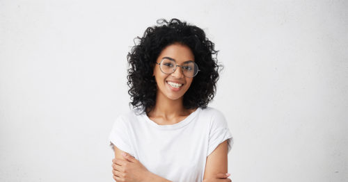 Young African-American woman in glasses smiling.