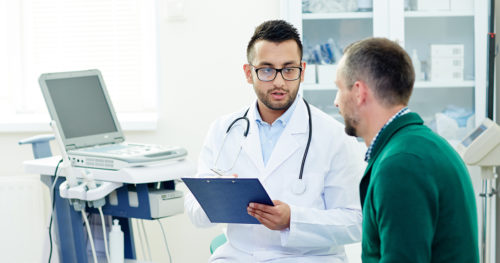 middle-aged man talks to doctor about prostate exams