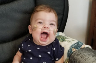Baby smiling in a chair.