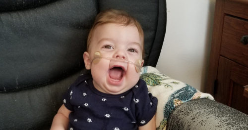 Baby smiling in a chair.