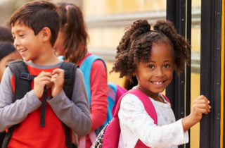young girl with a backpack boarding a school bus