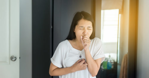 Asian-American woman with pneumonia coughing.
