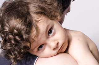 young boy with measles being comforted by father