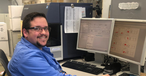 Joshua Barrett, Clinical Laboratory Scientist. He is working in our Flow Cytometry department, analyzing sample results and graphs.
