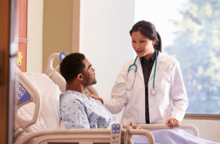 Physician consulting with patient in hospital shortly before surgery