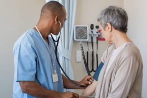 male nurse taking female patient's blood pressure