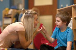 Therapist playing with young boy with autism
