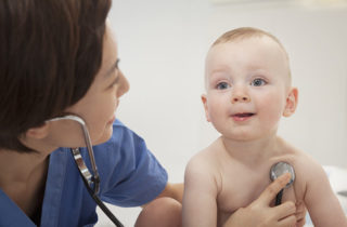 nurse taking infant boy's vital signs