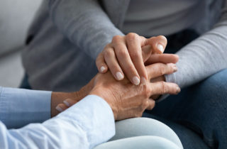 Grief support group participants holding hands