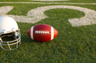 Football and helmet on field