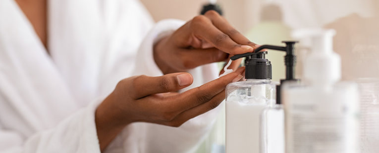 Woman applying moisturizing lotion on her dry hands.