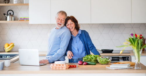 Senior couple cooking healthy food in kitchen.