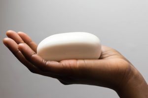 African-American woman's hand holding a bar of soap.