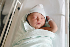 Newborn infant in hospital crib.