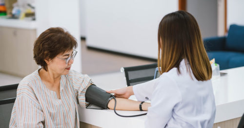 Female with hypertension getting blood pressure checked by health care provider.