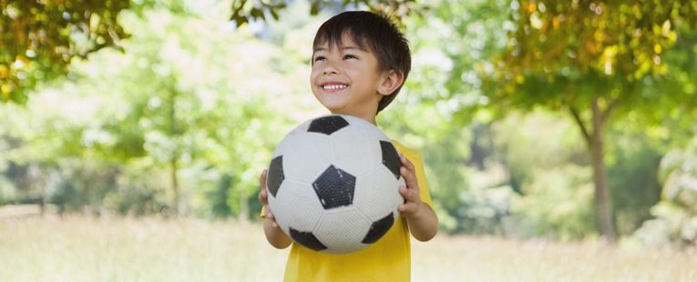 Boy with soccer ball after returning to sports after COVID-19.