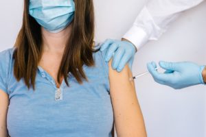 masked woman recieves a vaccine