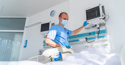 ICU nurse preparing a patient bed.