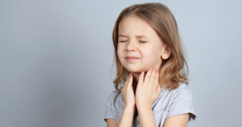 little girls holds her throat in obvious pain