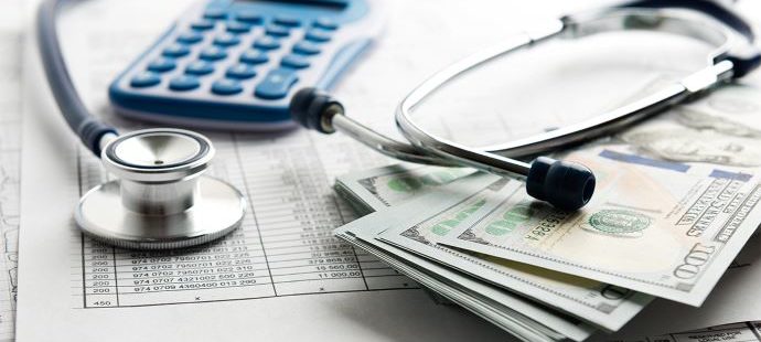 Medical expenses and paying for cancer treatment can be expensive. Image of a stethoscope, a bill, a calculator and cash.