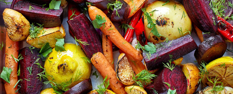 Photo of assorted roasted vegetables including shaved carrots, lemons and assorted root vegetables