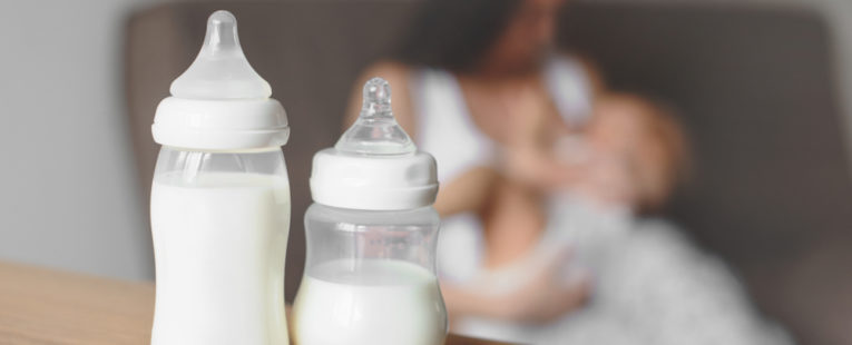Mother with baby and baby formula or milk in bottles