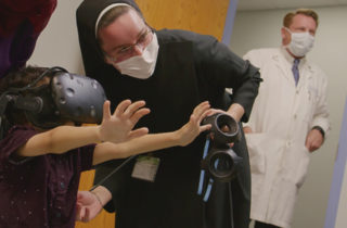 Sister Pieta and a child showcase the use of virtual reality.