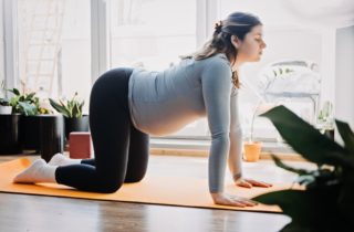 A woman does yoga to safely exercise her pelvic floor muscles during pregnancy.