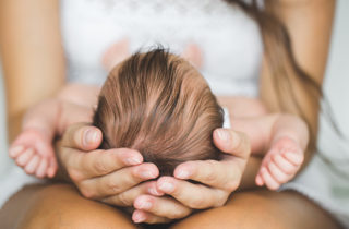 mom holding baby's head, cradle cap, infant hygiene