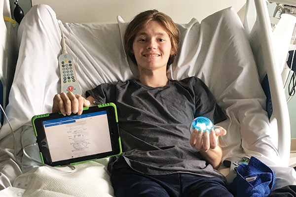 boy playing with STEAM game in a hospital bed