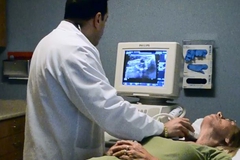 Doctor performing thyroid ultrasound