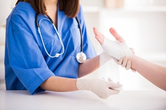 Nurse dressing hand wound