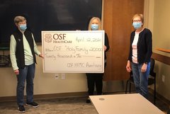 The OSF HealthCare Holy Family Medical Center Auxiliary donated a $20,000 check to Lisa DeKezel, interim president of OSF Holy Family.