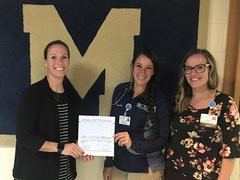 Photo of Brooke Rick, Principal of Marquette Academy, accepting a donation of $900 from OSF HealthCare representatives Brandi Peters, Athletic Trainer, and Alisha Jackson, Advance Practice Registered Nurse in Family Medicine.